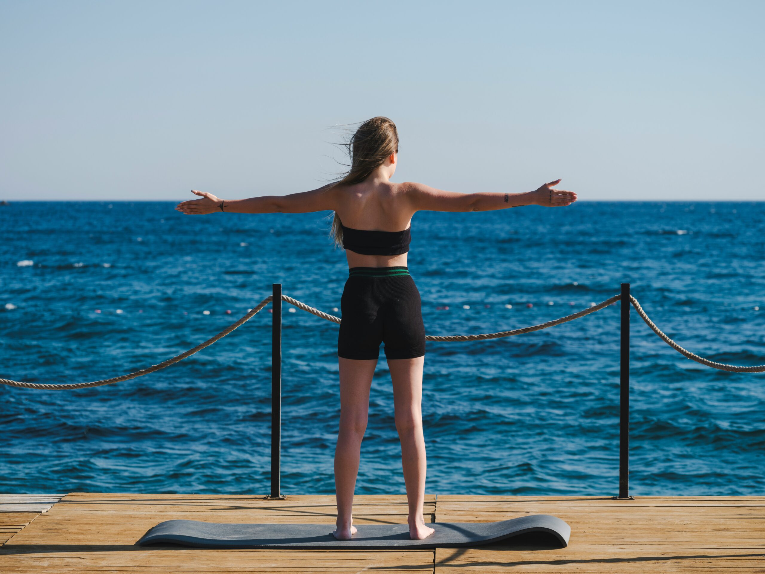 Yoga session on a dock overlooking the sea